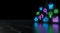 Colorful neon business icons floating above dark surface with glowing reflections for digital marketing and e-commerce presentations.