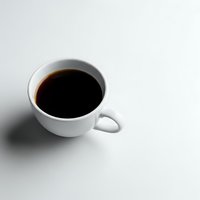 White ceramic coffee cup filled with black coffee on clean white background with soft shadow for morning beverage and cafe concepts.