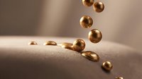 Golden spheres cascading down a curved sand surface with soft natural lighting, suitable for luxury branding, wellness products, and abstract design projects.