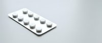 White medication pills in blister pack on clean background for pharmaceutical and healthcare concepts.