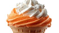 Orange and vanilla soft serve ice cream swirled in waffle cone topped with whipped cream, isolated on white background for dessert menu designs.