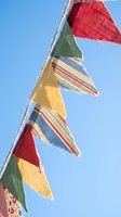 Colorful fabric bunting flags hanging on rope against clear blue sky for outdoor party decoration and festive celebration events.