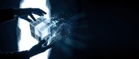 Hands holding glowing transparent cube with digital particles and light effects in dark atmospheric setting for technology and innovation concepts.