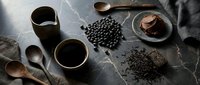 Dark moody coffee scene with black beans, brewing equipment and chocolate dessert on rustic wooden surface for cafe branding and food photography.