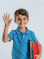 Young Latino student in blue polo shirt holding colorful school supplies waves hello with cheerful smile against light background. Great for education themes.