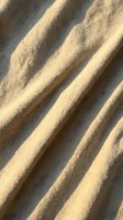 Sand dunes with diagonal ridges and shadows creating natural texture and pattern. Suitable for backgrounds, travel, nature, and desert-themed design projects.