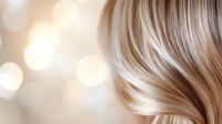 Silky smooth blonde hair strands flowing with soft bokeh light effect in background, showcasing natural shine and movement for beauty and haircare advertising.