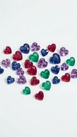 Colorful heart-shaped gemstones in ruby red, sapphire blue, emerald green and amethyst purple scattered on white background for jewelry design.