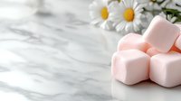 Pink marshmallows on marble surface with fresh daisies creating soft, romantic composition. Natural light and selective focus enhance delicate mood.