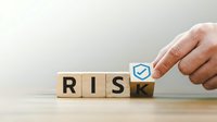 Business hand turning wooden cube from word risk to safe with checkmark symbol for risk management and safety concept.