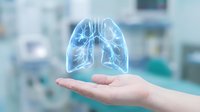Holographic lungs floating above open palm in medical setting, representing respiratory health, pulmonology care and healthcare technology innovation.