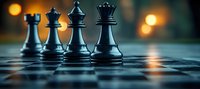 Black chess pieces on board with dramatic lighting and bokeh effect in background, strategic game concept showing power and leadership positioning.
