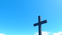 Christian cross silhouette against bright blue sky with white fluffy clouds, dramatic religious symbol photographed from low angle perspective.