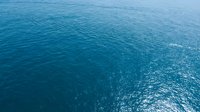 Deep blue ocean water surface with gentle ripples and sunlight reflections creating sparkling patterns across the vast seascape for marine backgrounds.
