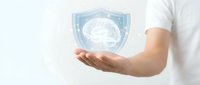 Hand holding holographic brain shield symbol representing mental health protection, cybersecurity, AI safety, medical insurance and neurological care concepts.