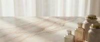 Sunlit wooden floor with vintage glass bottles creating warm shadows near window with flowing curtains for natural home decor and wellness concepts.