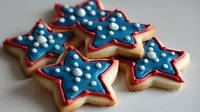 Patriotic star sugar cookies decorated with blue icing and white dots, red outline on beige background, festive American holiday baked treats for celebrations.