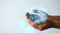 Hands holding glowing digital globe with blue light effects, representing global connectivity, technology innovation, and worldwide business communication networks.