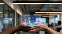 Businessman hands holding holographic digital interface with data analytics charts and global network connections in modern office environment.