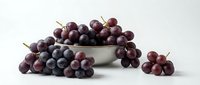 Fresh red grapes in white bowl on clean background, healthy organic fruit for cooking, wine making and nutritious snacking.