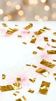 Golden confetti and pink glitter scattered on white surface with warm bokeh lights background for party celebration and festive event decoration.