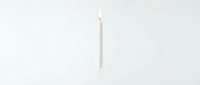 Single white taper candle with a burning flame isolated on a clean white background, evoking simplicity, elegance, and calm ambiance.