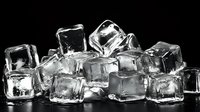 Transparent ice cubes pile on black background, showing crystal clear frozen water with reflective surfaces and melting edges for beverage photography.