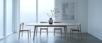 Modern minimalist dining room with wooden table and chairs in bright natural light interior space for contemporary home design and furniture showcase.