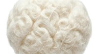 Fluffy white curly hair texture or wig with voluminous waves, suitable for costume design, character styling, theatrical productions, or fashion photography projects.