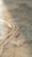 Abstract swirling cream and beige fluid motion with soft flowing curves creating elegant organic patterns for modern design backgrounds.