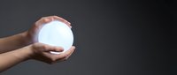 Hands holding glowing white orb of light against dark background symbolizing energy, power, protection and spiritual enlightenment for wellness concepts.