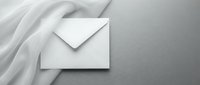 White envelope on soft fabric background with elegant shadows and minimalist composition for business correspondence and mailing concepts.