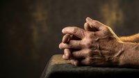 Weathered hands of an elderly person resting on a surface, showing age spots and wrinkles, conveying wisdom, experience, and the passage of time for healthcare, aging, and life stages.