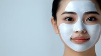 Young Asian woman applying white clay facial mask for skincare routine and beauty treatment at home spa.
