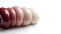 Colorful glazed donuts arranged in gradient from dark red to white on clean background for bakery and dessert concepts.