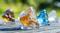 Colorful crystal stones on rustic wooden surface with natural bokeh background, amber and blue minerals in sunlight, macro photography for wellness decor.