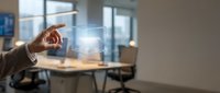 Businessman touching digital holographic interface with glowing light in modern office workspace for technology and innovation concepts.