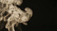 Elegant white smoke swirls creating abstract flowing patterns against black background for artistic design projects and creative compositions.