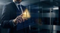Professional businessman in dark suit touching glowing warning triangle icon on futuristic digital interface for cybersecurity and risk management concepts.
