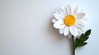 Single white paper daisy with yellow center and green leaf on light background, handcrafted decorative element for creative projects and celebrations.