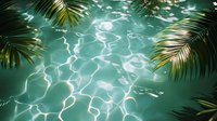 Tropical swimming pool with crystal clear turquoise water reflecting sunlight, framed by lush palm fronds creating a serene vacation atmosphere.