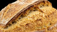 Artisan sourdough loaf with crusty golden-brown exterior and scoring marks, isolated on transparent background. Ready for bakery designs, food packaging, menus, print-on-demand products, and culinary graphics.