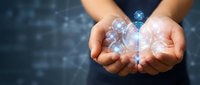 Hands holding glowing digital brain with neural network connections on dark tech background, representing artificial intelligence, innovation, and future technology concepts.