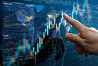 Hand pointing at financial trading charts and stock market data on digital screen with candlestick graphs and technical analysis indicators.