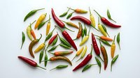 Colorful hot chili peppers scattered on white background. Fresh spicy vegetables in red, green and yellow colors for cooking and culinary design projects.