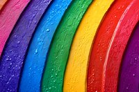 Vibrant curved rainbow stripes with water droplets creating textured surface, macro photography showing detailed wet colorful pattern in pink, purple, blue, green, yellow and red.