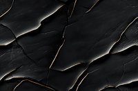 Dark textured stone surface with diagonal cracks and layered edges creating dramatic shadows and depth, suitable for luxury brand backgrounds and modern design projects.