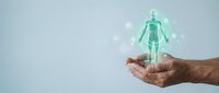 Hands holding glowing green holographic human figure representing healthcare technology, medical innovation, digital health solutions and futuristic medicine concepts.