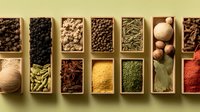 Assortment of colorful culinary spices and herbs in wooden compartments, including peppercorns, cardamom, star anise, turmeric, and nutmeg for cooking.