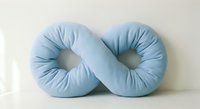 Blue fabric infinity symbol pillow cushion on white background isolated for home decor and comfort design projects.